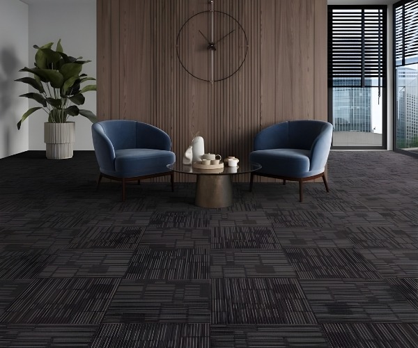 "Modern office space in Sydney featuring stylish dark-patterned carpet tiles, two blue accent chairs, and a contemporary wooden feature wall.