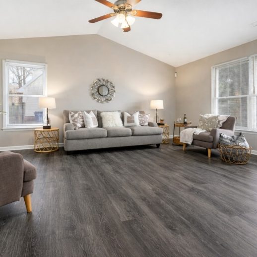 Contemporary living room showcasing professional hybrid flooring installation in Melbourne, featuring durable dark timber-look planks with a seamless, modern finish.